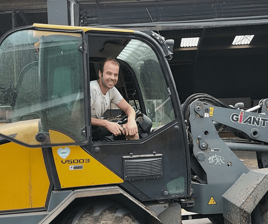 Melkveehouder Arne Reuvers op zijn shovel op het erf