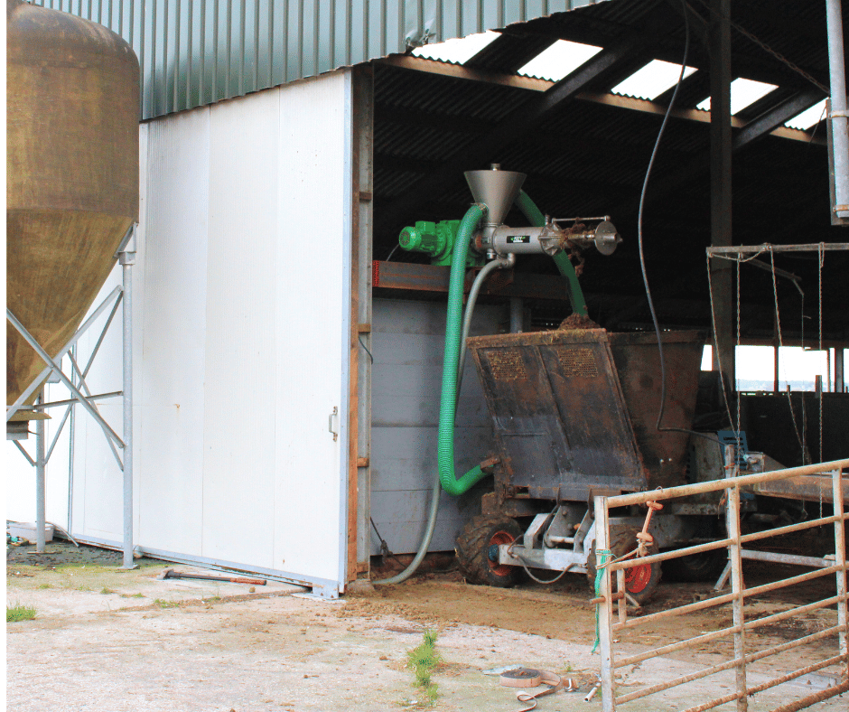 Mestscheider in de stal met eronder de bak van de instrooiwagen om dikke fractie op te vangen