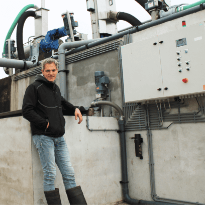 Veehouder Edwin Dinkelman trots naast zijn innovatieve mestinstallatie
