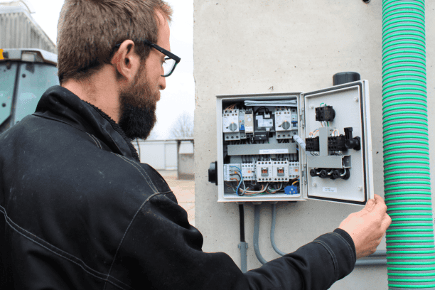 Veehouder Jan Willem van Zandwijk bij besturingskast van scheider en pomp