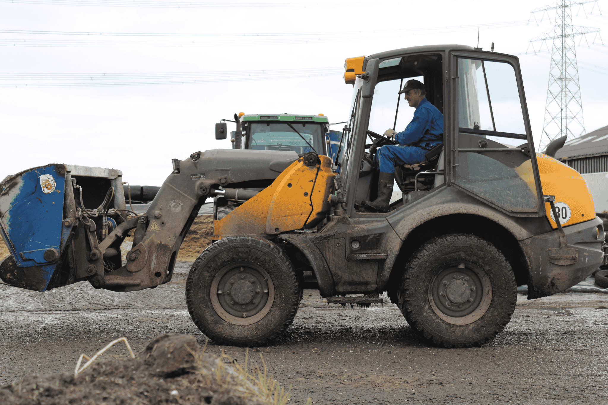 Melkveehouder Wilfred Hartjes uit Appingedam op zijn shovel aan het kuilrijden